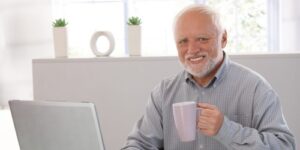 Homem tomando café em frente ao computador